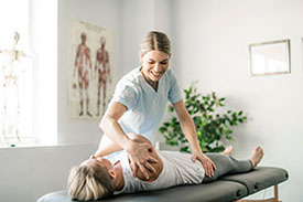 Michele McCarthy stretching the leg of a client